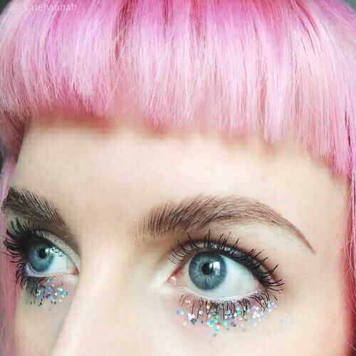 Girl with pastel pink hair and glitter makeup on eyes