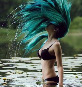 Alternative pale girl with mermaid blue dyed hair with bikini on water cover