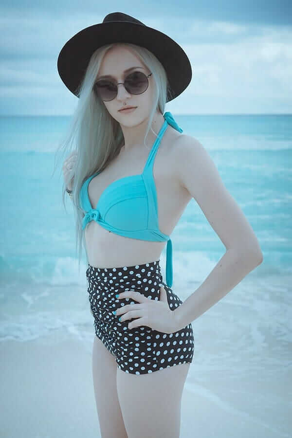 Retro bikini set featuring a bright turquoise top and high waisted polka dot bottoms, with a black fedora 2