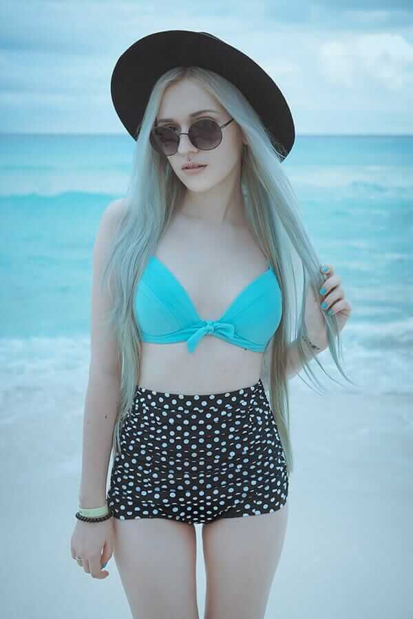 Retro bikini set featuring a bright turquoise top and high waisted polka dot bottoms, with a black fedora
