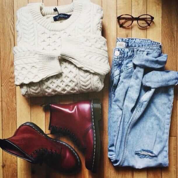 11. Cream cable knit sweater, blue jeans, crimson Doc Martens, and clear lens glasses