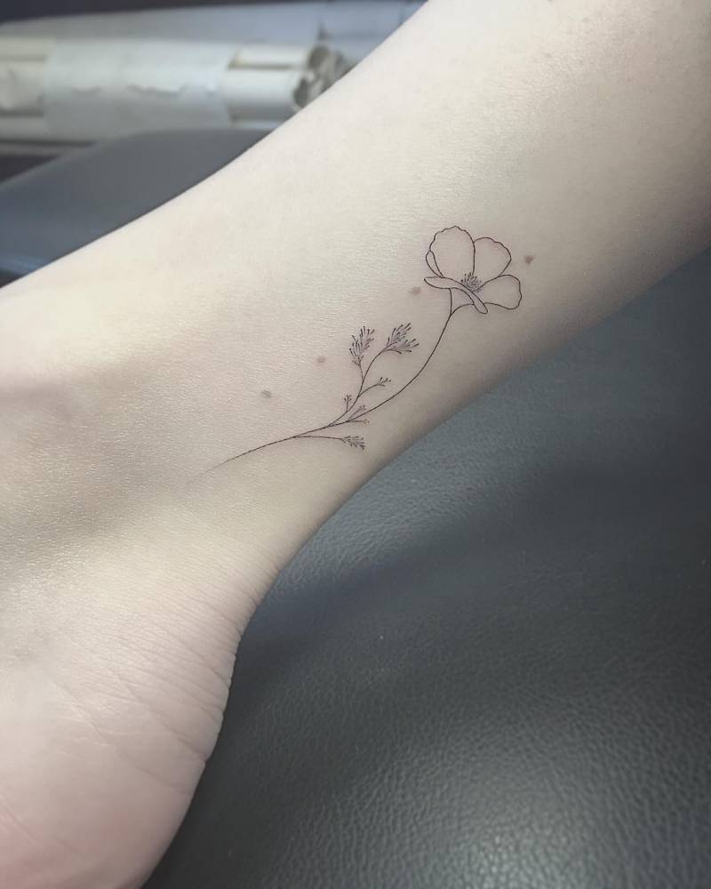 Fine line flower tattoo on the right inner ankle