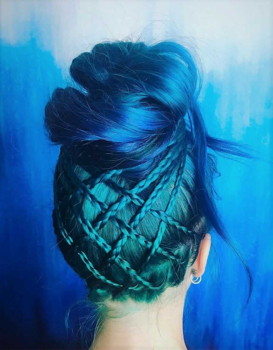 Blue and turquoise dyed hair with high bun by vertigohairnyc