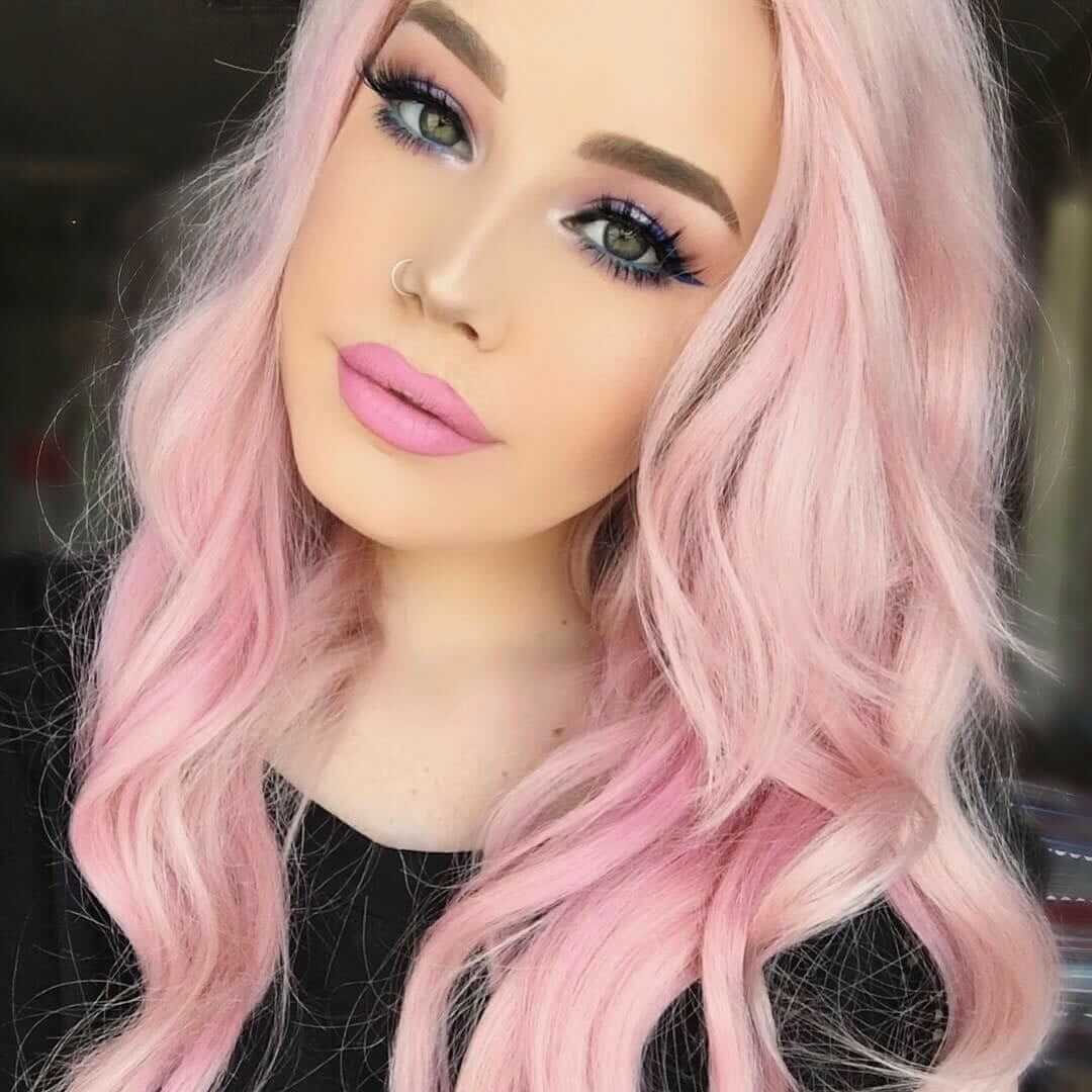 Curly pastel pink hairstyle by hailiebarber