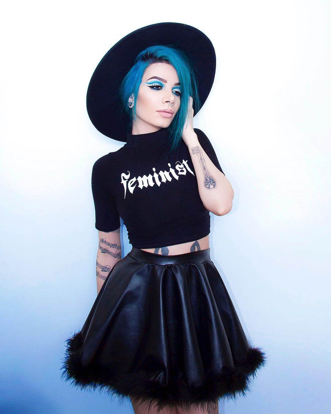 Brim hat with "Feminist" printed graphic soft crop top in black & fluff trim vinyl swing skirt by lilmoonchildd