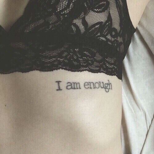 "I am enough" torso side quote tattoo